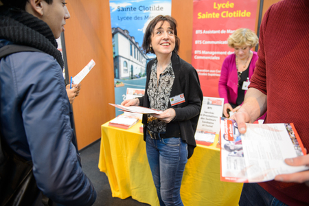 STRASBOURG, FRANCE - FEB 4, 2016: Children and teens of all ages attending annual Education Fair to choose career path and receive vocational counseling - professor at lyceum standのeditorial素材
