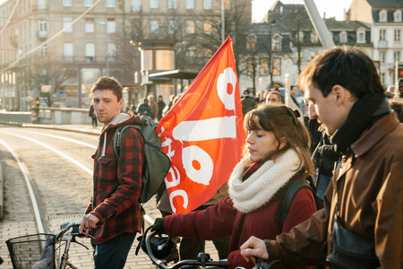 STRASBOURG, FRANCE - FEB 6, 2016: Communist flags in hands of protesters marching during a demonstration against government's plan to extent the 'state of emergency' and for opened bordersのeditorial素材