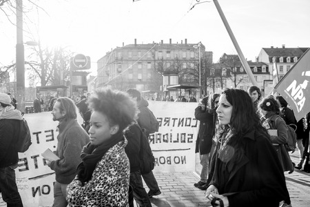 STRASBOURG, FRANCE - FEB 6, 2016: Communist flags in hands of protesters marching during a demonstration against government's plan to extent the 'state of emergency' and for opened bordersのeditorial素材