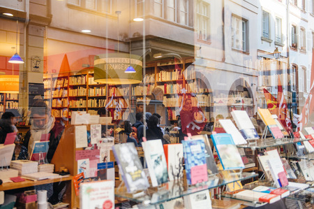 STRASBOURG, FRANCE - FEB 6, 2016: Protesters marching during a demonstration against government's plan to extent the 'state of emergency' and for opened borders - reflection of protesters in library windowのeditorial素材