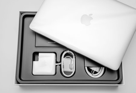 PARIS, FRANCE - JANUARY 14, 2015: New Apple MacBook Pro laptop covered by the plastic film and all its accesories in the box seen from above during the unboxing processのeditorial素材