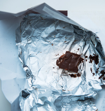 Last chocolate part in the aluminium foil on deskの写真素材