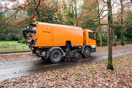 BADEN, BADEN, GERMANY - NOV 20, 2014: Orange Bucher CityFant 60 street sweeper machine cleaning the street after in fall from fallen foliageのeditorial素材