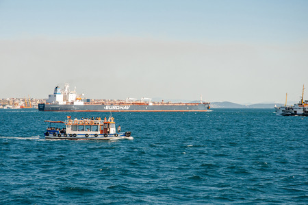 ISTANBUL, TURKEY - JUL 28, 2009: Tourist boat and cargo construction boat in Bosphorus strait on a beautiful summer day with the city of Istanbul behindのeditorial素材