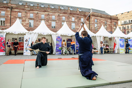 STRASBOURG, FRANCE - APRIL 24, 2015: Samurai sword public demonstration by two men wearing traditioanl samurai Hakama in Place Kleber, Strasbourg, Alsace, Eurometropoleのeditorial素材