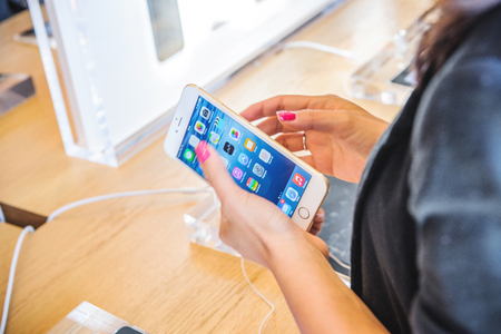 PARIS; FRANCE - SEPTEMBER 20; 2014: Woman testing new iPhone 6 Plus during the sales launch of the latest Apple Inc. smartphones at the Apple store in Paris; Franceのeditorial素材