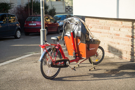 STRASBOURG, FRANCE - DEC 25, 2015: Cargo bike with protect tent parked on the street. The cargobike made by Bakfiets netherlands is a transport bicycle that's user friendly and ensures absolute cycling pleasureのeditorial素材