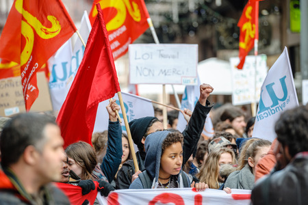 STRASBOURG, FRANCE - 9 MAR 2016: Protester with rised hands in front row of thousands of people demonstrating as part of nationwide day of protest against proposed labor reforms by Socialist Governmentのeditorial素材