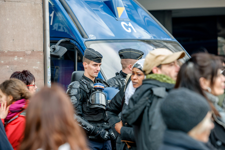 STRASBOURG, FRANCE - 9 MAR 2016: Police officers surveilling street as thousands of people demonstrate as part of nationwide day of protest against proposed labor reforms by Socialist Governmentのeditorial素材