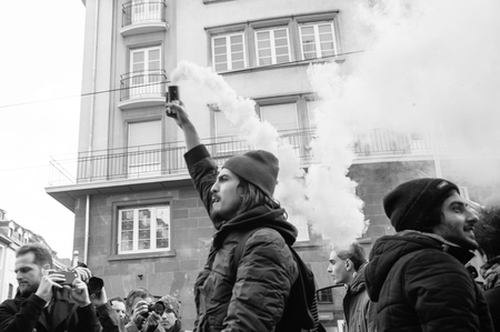 STRASBOURG, FRANCE - 9 MAR 2016: People burn flares and smokes grenade as thousands of people demonstrate as part of nationwide day of protest against proposed labor reforms by Socialist Governmentのeditorial素材