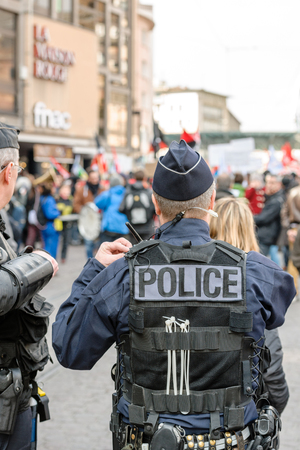 STRASBOURG, FRANCE - 9 MAR 2016: Surveilling police officer as thousands of people demonstrate as part of nationwide day of protest against proposed labor reforms by Socialist Governmentのeditorial素材