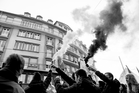 STRASBOURG, FRANCE - 9 MAR 2016: People burn flares and smokes grenade as thousands of people demonstrate as part of nationwide day of protest against proposed labor reforms by Socialist Governmentのeditorial素材