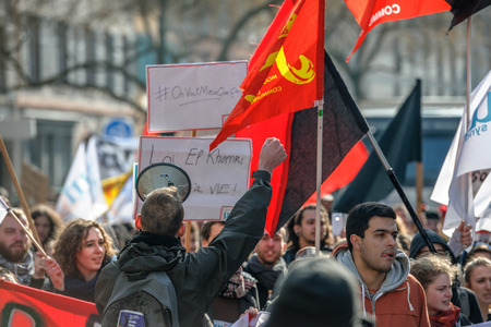 STRASBOURG, FRANCE - 9 MAR 2016: Man rising hand in front of crowd as thousands of people demonstrate as part of nationwide day of protest against proposed labor reforms by Socialist Governmentのeditorial素材