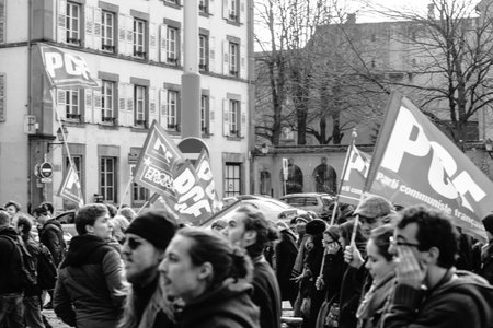 STRASBOURG, FRANCE - 9 MAR 2016: French communist flags waving as thousands of people demonstrate as part of nationwide day of protest against proposed labor reforms by Socialist Governmentのeditorial素材