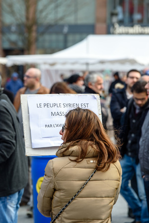 STRASBOURG, FRANCE - MAR 19, 2016: Woman reading placard as  Syrian diaspora protests in center of Strasbourg to denouncing the Syrian attacks and show solidarity with the Syrian peopleのeditorial素材