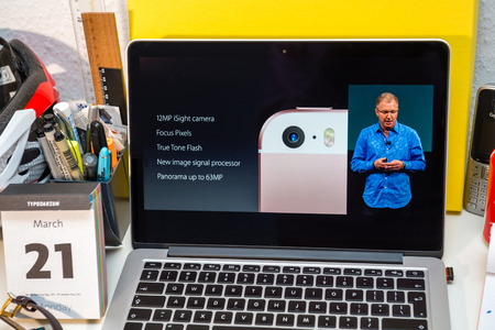 PARIS, FRANCE - MARCH 21, 2016: Apple Computers website on MacBook Pro Retina in a creative room environment showcasing Apple Event with Greg Joswiak presenting iPhone SE camera specsのeditorial素材
