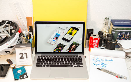 PARIS, FRANCE - MARCH 21, 2016: Apple Computers website on MacBook Pro Retina in a geek creative room environment showcasing the newly announced iPhone SE with diverse media on screenのeditorial素材