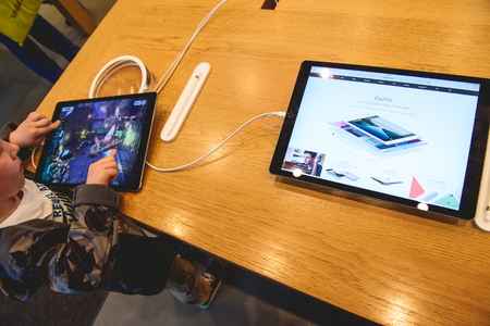 PARIS, FRANCE - APR 4, 2016: Kid playing game on the new 9.7-inch iPad Pro during the sales launch of the latest Apple Inc. smartphone and iPad Pro at the Apple store in Paris, Franceのeditorial素材