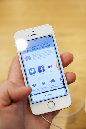 PARIS, FRANCE - APR 4, 2016: Sharing content via social network or air play with the new Apple iPhone SE during the sales launch of the latest Apple Inc. smartphone and iPad Pro at the Apple store in Paris, Franceのeditorial素材
