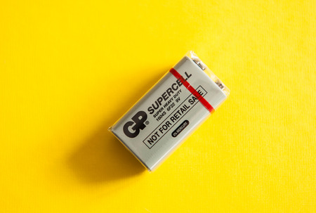 PARIS, FRANCE - MAR 02, 2015: New nine-volt battery or 9-volt battery on a yellow background made by GP Supercell - Super Heavy Duty with 0% mercury. The standard name for this battery is PP3-size 9-volt alkaline batteryのeditorial素材