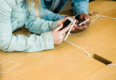 STRASBOURG, FRANCE - APR 9, 2016: Young friends comparing the new Apple SE and iPhone 4 and iPhone 6S phone during the sales launch of the latest Apple Inc. smartphones at the Apple store in Paris, FranceiPhone SE was released on March 31, 2016のeditorial素材