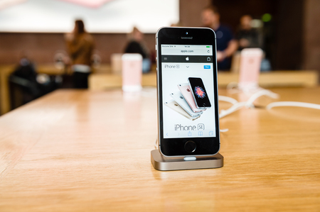 STRASBOURG, FRANCE - APR 9, 2016: New iPhone SE in docking station with Apple.com page opened. New Apple iPhone tends to become one of the most popular smart phones in the world.のeditorial素材