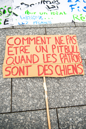 STRASBOURG, FRANCE - APR 9, 2016: French placard reading "How not to transform yourself in a pitbull when your boss is a dog" during public placard drawings in Place Kleberのeditorial素材