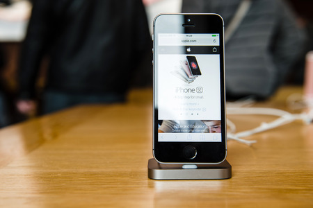 STRASBOURG, FRANCE - APR 9, 2016: New iPhone SE in docking station with Apple.com page opened. New Apple iPhone tends to become one of the most popular smart phones in the world.のeditorial素材