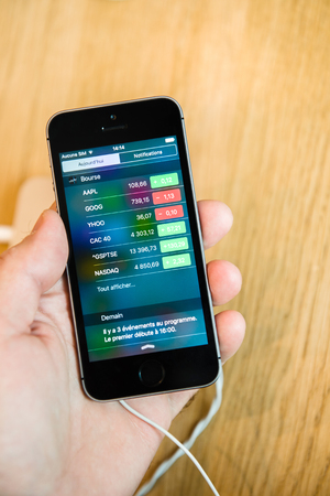STRASBOURG, FRANCE - APR 9, 2016: Recently launched iPhone SE smartphone mobile phone with Stock Market app runing testing deciding to buy it. iPhone SE was released on March 31, 2016のeditorial素材