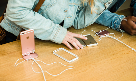 STRASBOURG, FRANCE - APR 9, 2016: Young friends comparing the new Apple SE and iPhone 4 and iPhone 6S phone during the sales launch of the latest Apple Inc. smartphones at the Apple store in Paris, FranceiPhone SE was released on March 31, 2016のeditorial素材