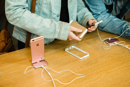 STRASBOURG, FRANCE - APR 9, 2016: Young friends comparing the new Apple SE and iPhone 4 and iPhone 6S phone during the sales launch of the latest Apple Inc. smartphones at the Apple store in Paris, FranceiPhone SE was released on March 31, 2016のeditorial素材