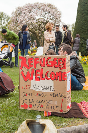 STRASBOURG, FRANCE - APR 9, 2016: Refugees welcome placard with people discussing at 'Nuit Debout' or 'Standing night' movement at the Place de la Republique in Strasbourgのeditorial素材