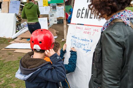 STRASBOURG, FRANCE - APR 9, 2016: Young kid wrating placard as people join the 'Nuit Debout' or 'Standing night' movement at the Place de la Republique in Strasbourgのeditorial素材
