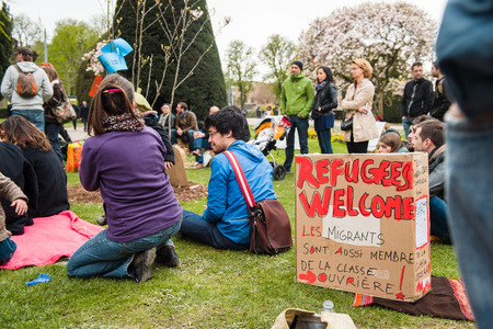 STRASBOURG, FRANCE - APR 9, 2016: Refugees welcome placard with people discussing at 'Nuit Debout' or 'Standing night' movement at the Place de la Republique in Strasbourgのeditorial素材