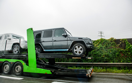 HUNGARY - SEPTEMBER 18, 2013: Modern New luxury Mercedes-Benz G-Class SUV cars being transported on a HODLMAYR trailer near Hungarian border. Hodlmayr is an Austrian international transportation companyのeditorial素材
