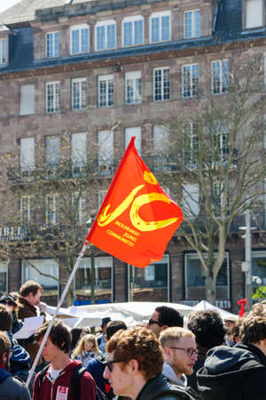STRASBOURG, FRANCE - APR 20, 2016: Young Communist Movement flag at protest of hundreds of people demonstrate as part of nationwide day of protest against proposed labor reforms by Socialist Governmentのeditorial素材