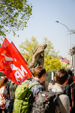 STRASBOURG, FRANCE - APR 20, 2016: American statue on bridge with hundreds of people demonstrate as part of nationwide day of protest against proposed labor reforms by Socialist Governmentのeditorial素材