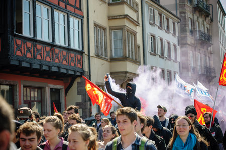 STRASBOURG, FRANCE - APR 20, 2016:Man holding smoke grenade as hundreds of people demonstrate as...