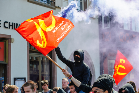 STRASBOURG, FRANCE - APR 20, 2016:Man holding smoke grenade as hundreds of people demonstrate as part of nationwide day of protest against proposed labor reforms by Socialist Governmentのeditorial素材