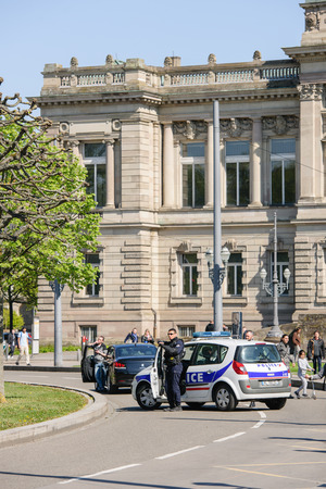 STRASBOURG, FRANCE - APR 20, 2016: Police car sruveilling closed street as hundreds of people demonstrate as part of nationwide day of protest against proposed labor reforms by Socialist Governmentのeditorial素材