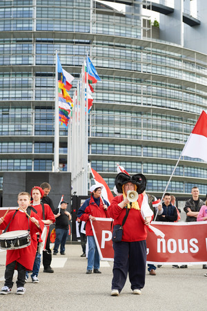 STRASBOURG, FRANCE - APR 30, 2016: Main entrance at European Parliament with crowd protesting against government regional reform for the fusion of the Alsace region with Lorraine and Champagne-Ardenneのeditorial素材