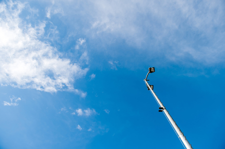 Lighting pole led street lamp seen from below against blue spring sky with bbeautiful cloudsのeditorial素材
