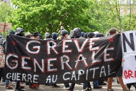 STRASBOURG, FRANCE - MAY 19, 2016: Group of youg people with covered faces holding placards walk with crowd during a demonstrations against proposed French government's labor and employment law reformのeditorial素材