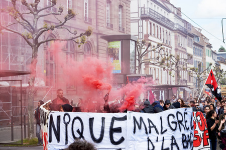 STRASBOURG, FRANCE - MAY 19, 2016: GRoup with covered faces and smoke grenades throwing paint towards Banque de France building during a demonstrations against proposed French government's labor and employment law reformのeditorial素材