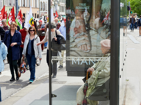 STRASBOURG, FRANCE - MAY 19, 2016:Senior woman watching protestors marching on closed street during a demonstrations against proposed French government's labor and employment law reformのeditorial素材
