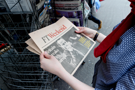 STRASBOURG, FRANCE - JUN 25, 2016: Woman buying Financial Times newspaper with shocking James Cameron PM headline titles at press kiosk about the Brexit referendum in United Kingdom requesting to quit the European Unionのeditorial素材