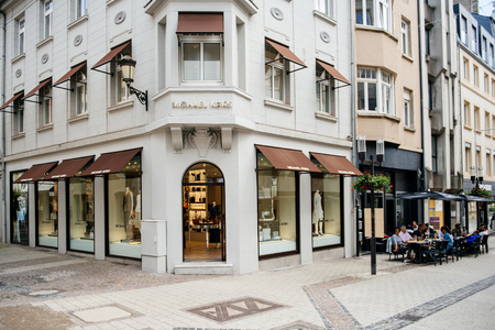 LUXEMBOURG, LUXEMBOURG - JUNE 5, 2016: Michael Kors luxury flagship store in the center of Luxembourg, with people eating at a cafe nearbyのeditorial素材