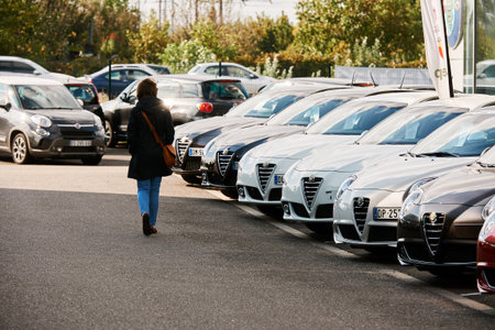 PARIS, FRANCE - OCT 10, 2015: Woman walking between rows of new car to choose the most precious one...