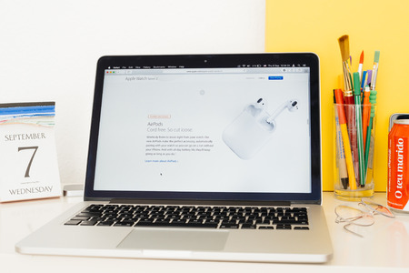 PARIS, FRANCE - SEP 8, 2016: Apple Computers website on MacBook Pro Retina in a geek creative room environment showcasing new Apple Watch Series 2 AirPod cordless earbuds headphonesのeditorial素材
