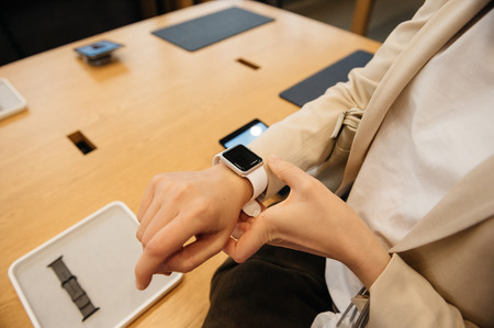 PARIS, FRANCE - SEPTEMBER 16, 2016: New Apple Watch Series 2 tested by woman after purchase - looking at the new strap, activity app. New Apple Watch tends to become one of the most popular wearable device in 2016のeditorial素材